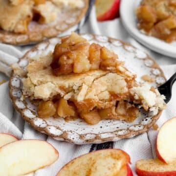 A cozy, warm slice of easy apple cobbler resting on a rustic plate with a fork.