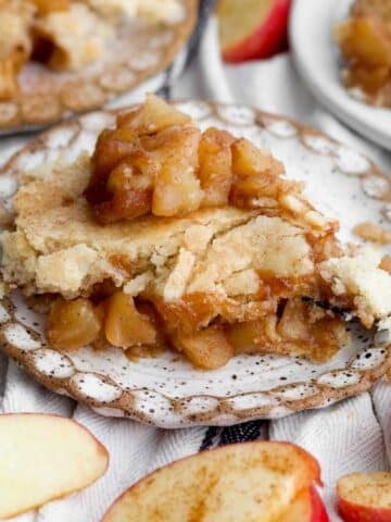 A cozy, warm slice of easy apple cobbler resting on a rustic plate with a fork.