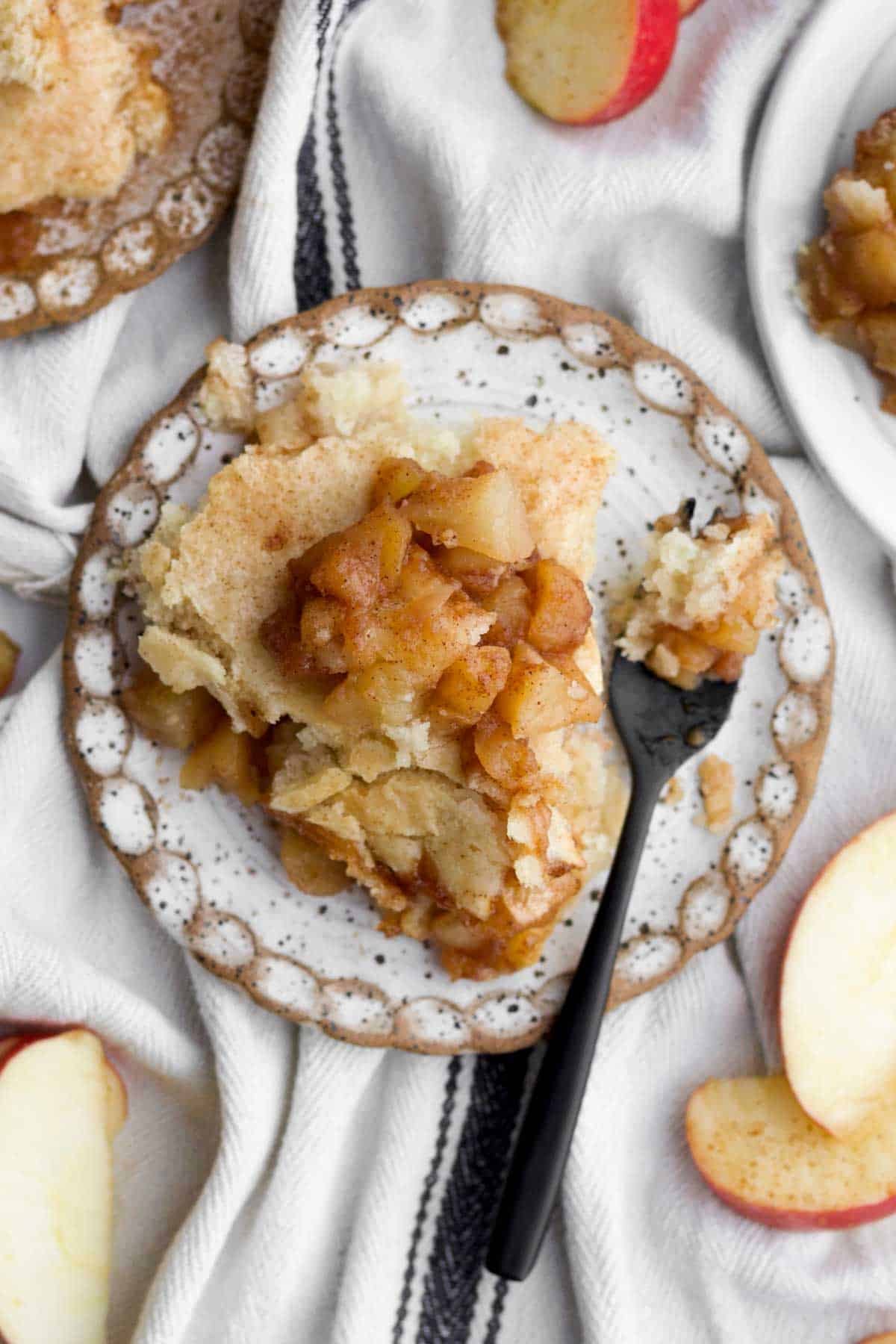 A golden slice of easy apple cobbler topped with a warm cinnamon-coated baked apples.