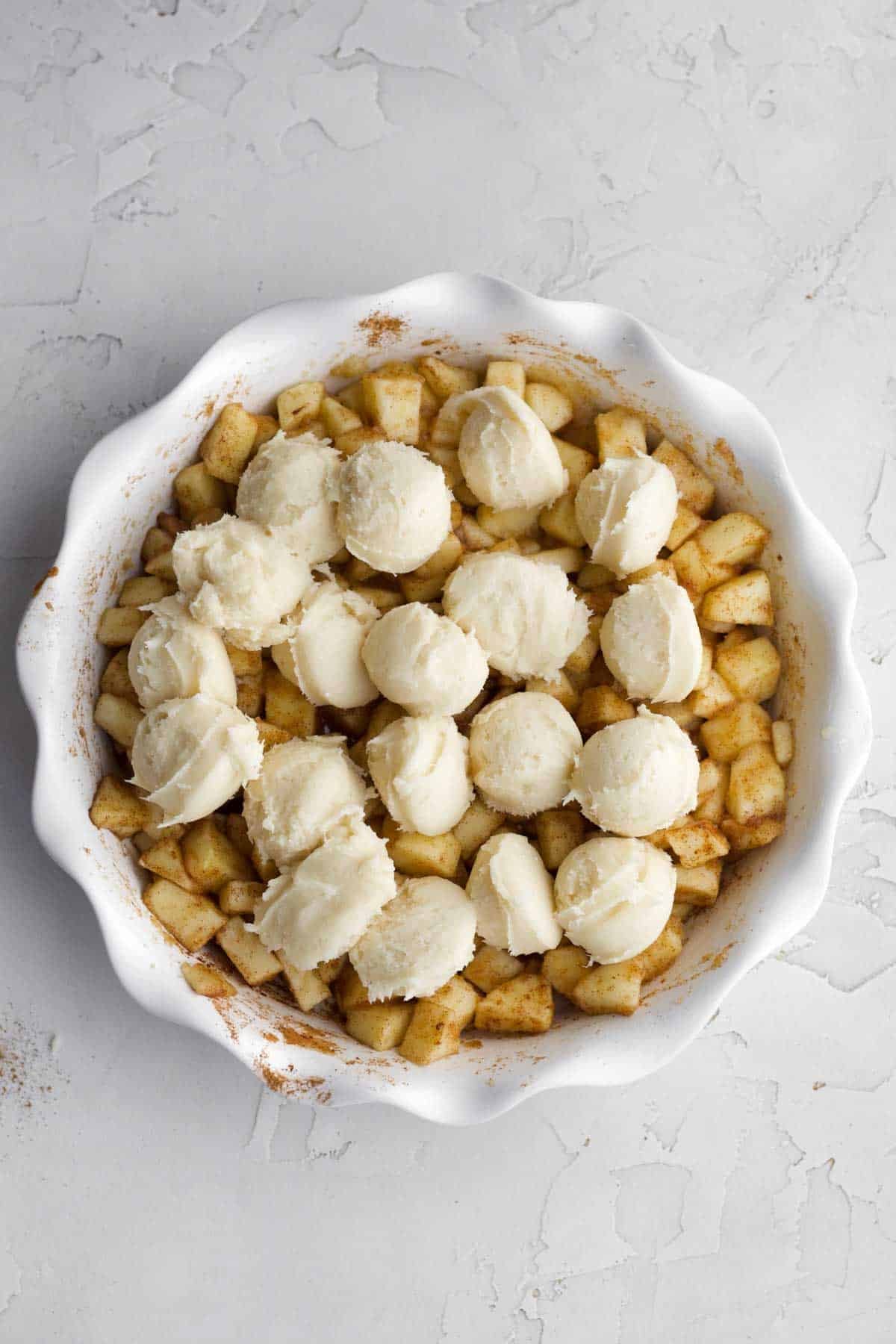 Scooping balls of batter in the baking dish.